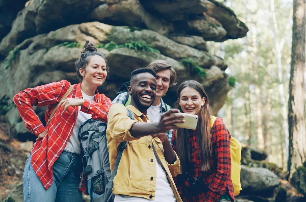 Group of young creators smiling and engaging with content together on their phones