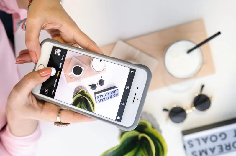 Content creator photographing a styled flat-lay with a smartphone to make an Instagram post worth liking