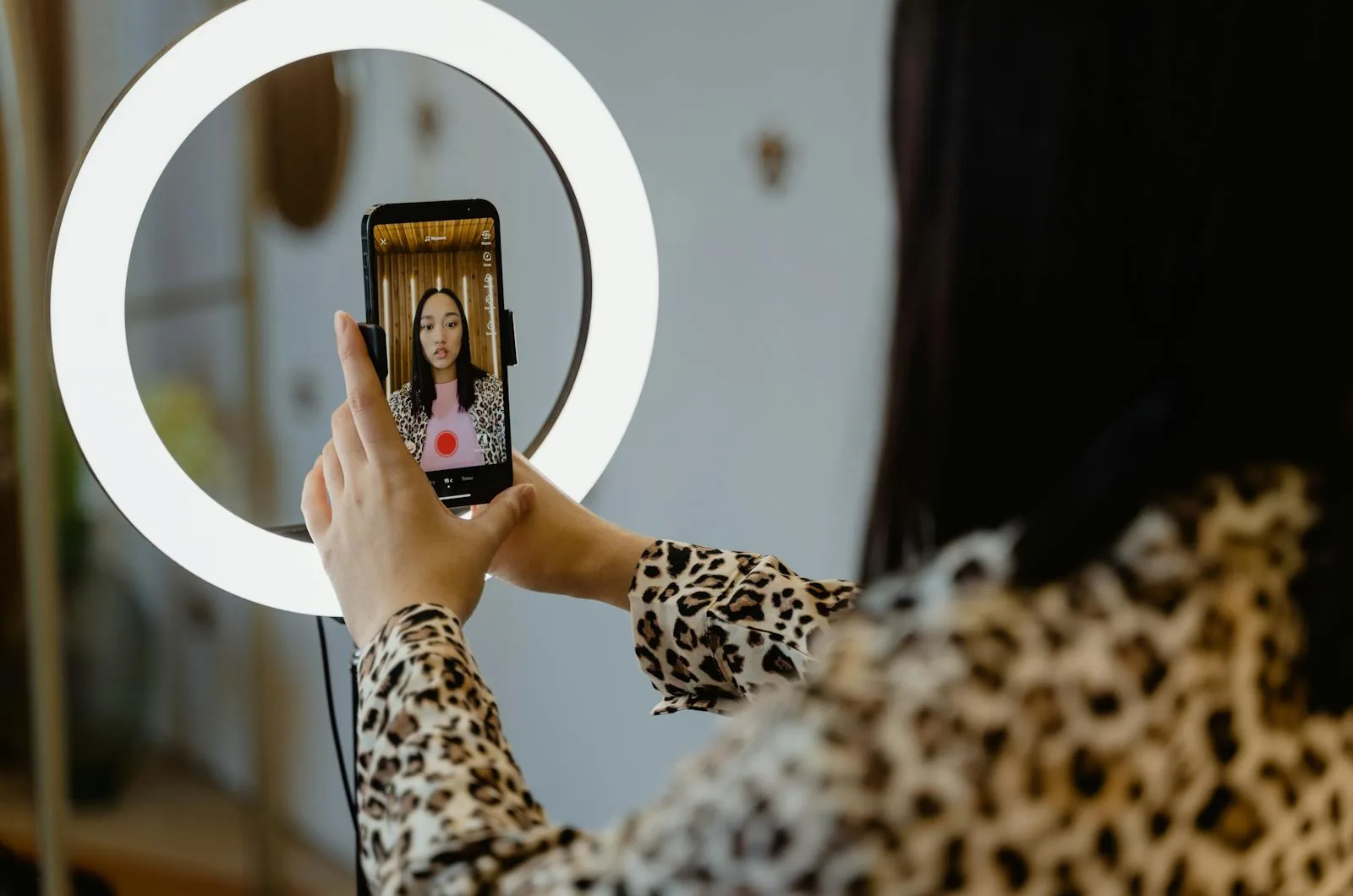 Content creator recording a vertical Instagram Reel on a smartphone mounted to a ring light