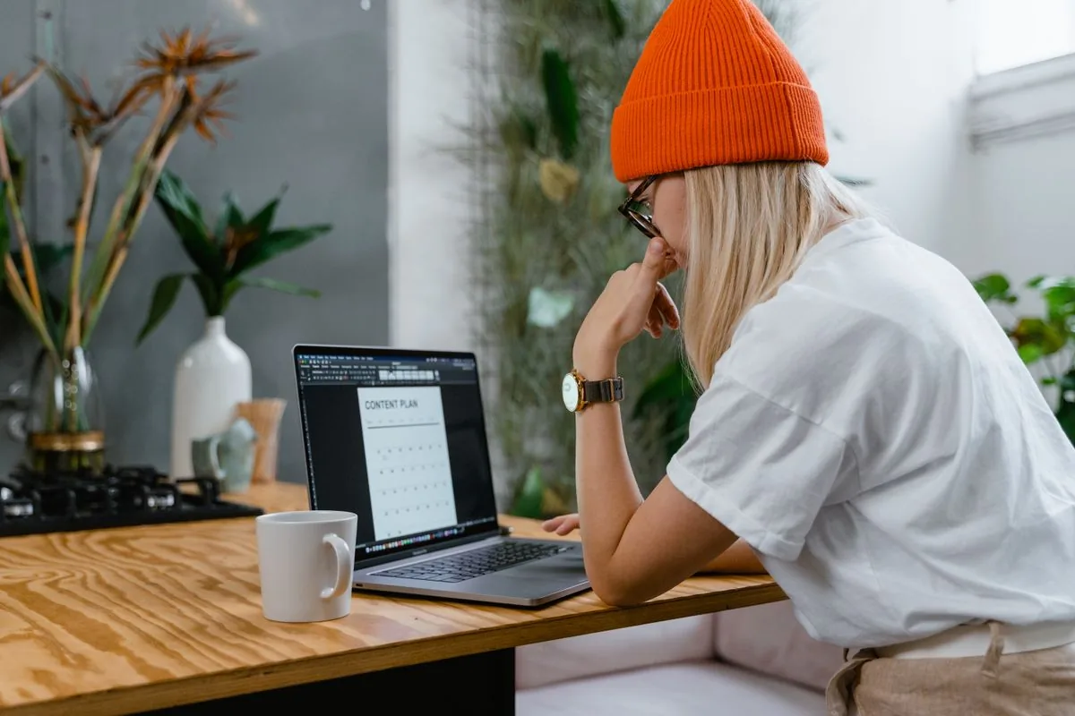 Creator at a desk with a laptop deciding how many TikTok followers to buy, delivered gradually for natural-looking growth