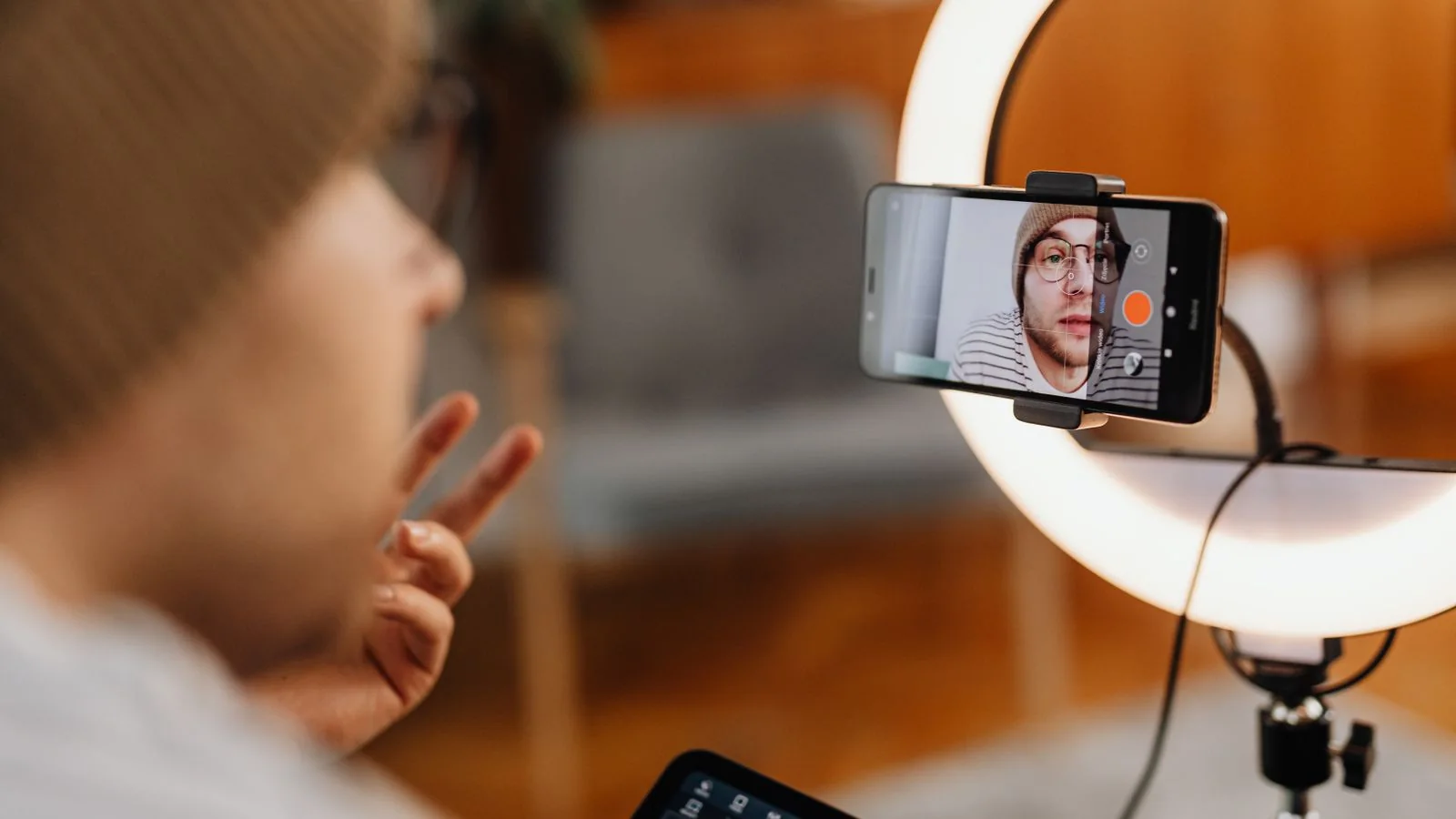TikTok creator filming a video and checking active like-count growth after buying active TikTok likes from BoostPals
