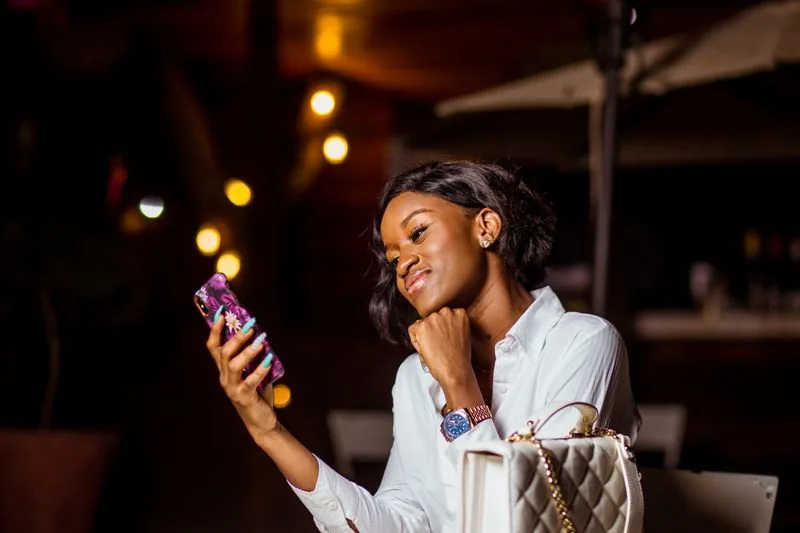 Person absorbed in watching a TikTok video on a phone, showing that watch time and completion matter more than the raw view count