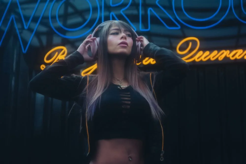 Twitch creator with headphones in a neon-lit setup making the VODs and clips that earn real views after buying Twitch views from BoostPals