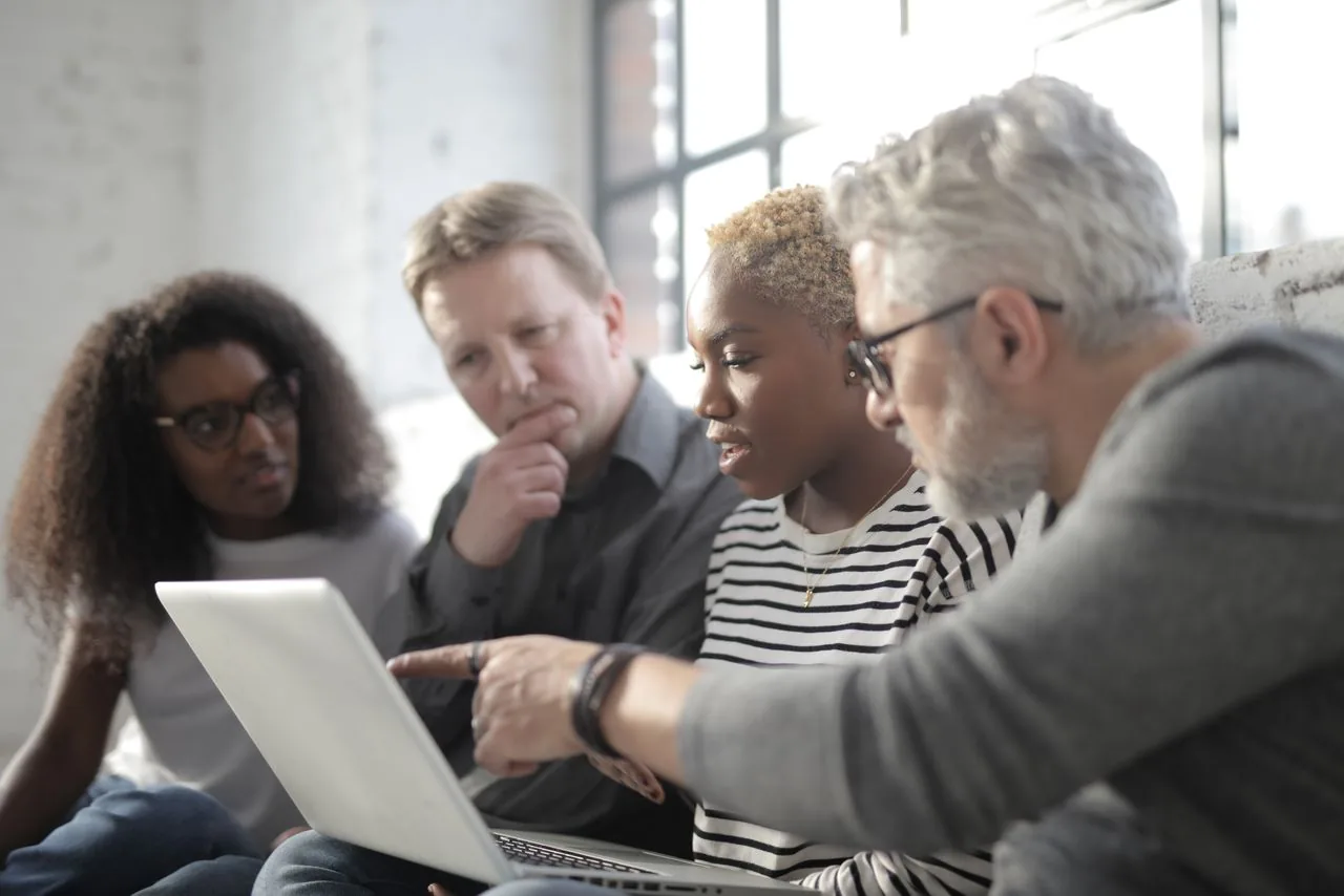 A team comparing providers on a laptop, the kind of vetting that separates real YouTube distribution from a bot share counter
